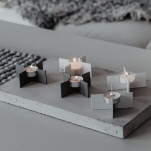 mattonella in cemento di spessore 3 cm utilizzata come vassoio centrotavola con tanti porta candele a forma di croce