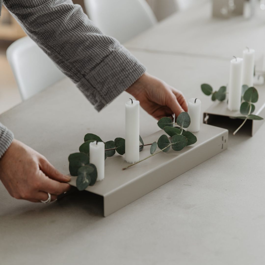 porta candele di design scandinavo in acciaio veniciato grigio chiaro. La forma rettangolare permette il posizionamento di 4 candele a stelo