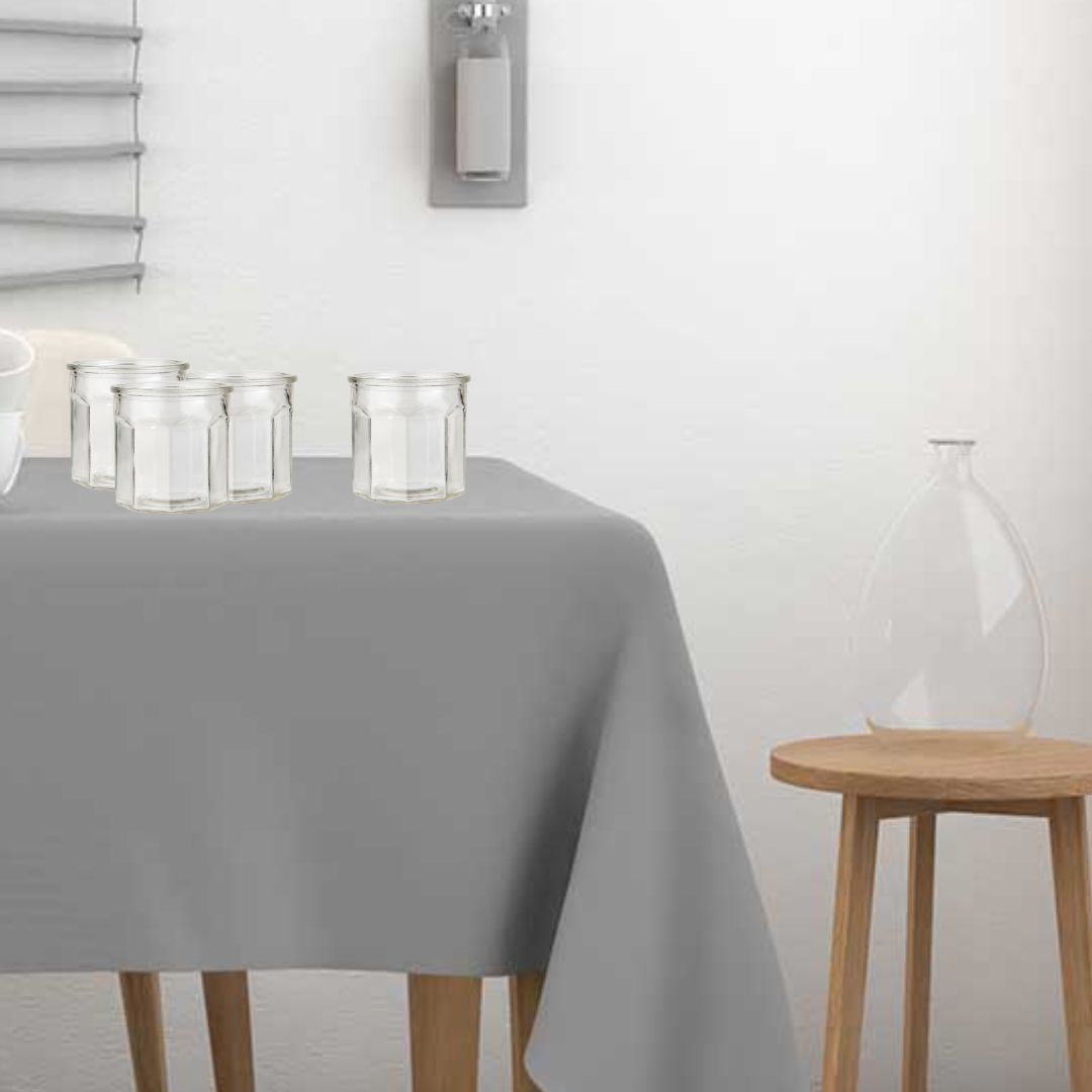 tavolo con tovaglia grigia con set di vasetti da dessert in vetro trasparente