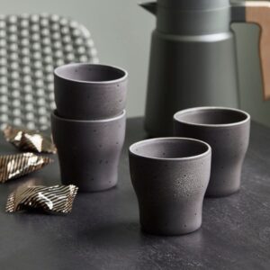 tavolo pronto per la pausa caffè apparecchiato con un set di 4 tazzine termiche in gres color antracite, una moka e del cioccolato