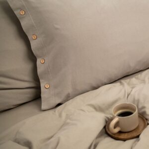 Completo letto composto da copripiumino singolo di misura 150x200 cm., federa cuscino 50x70 cm. e lenzuolo coprimaterasso con angoli 140x200 cm. Tutto il coordinato è in jersey di puro cotone di color taupe e il sacco copripiumino e la federa sono chiusi da raffinati bottoni in legno naturale