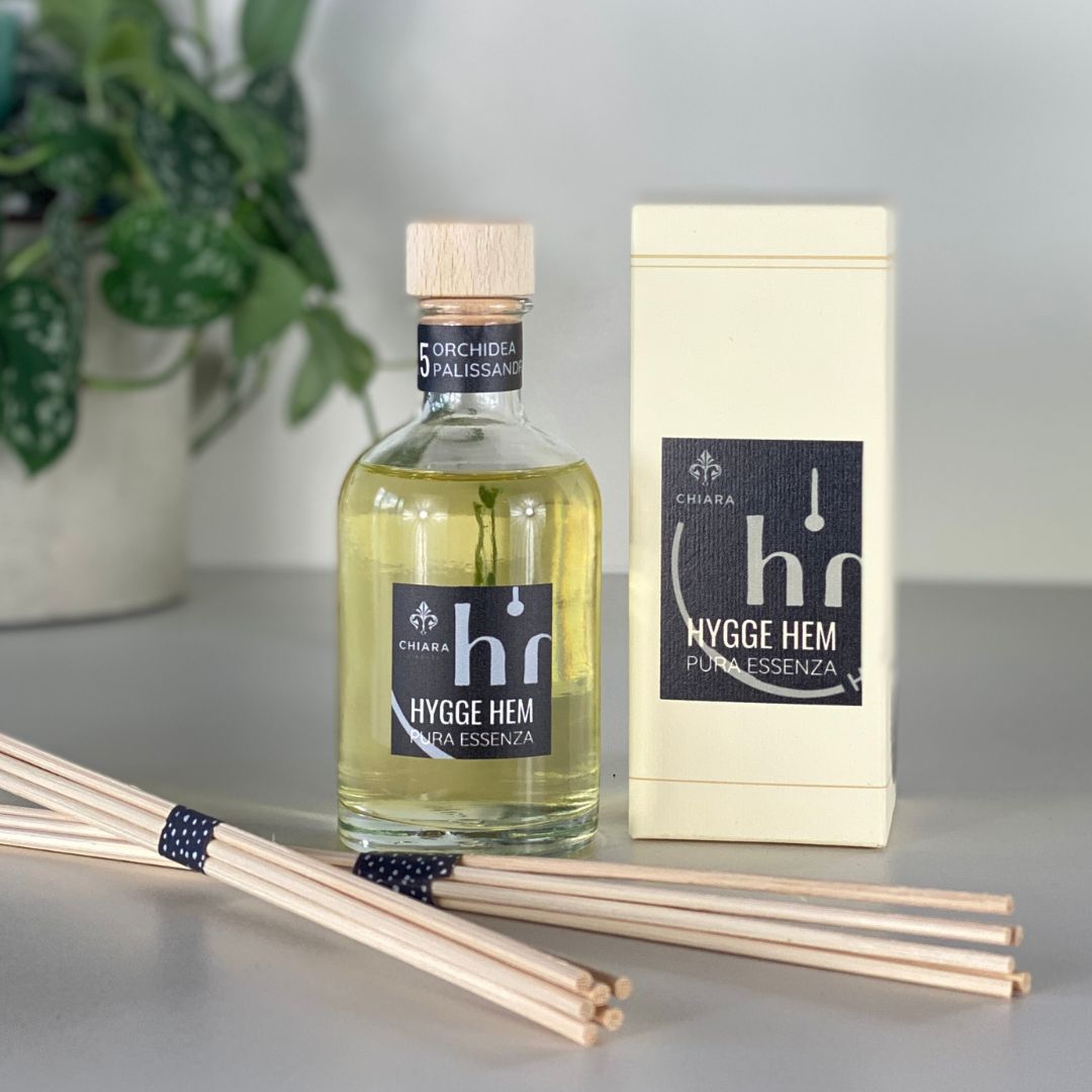 fragranza d'ambiente con diffusore a bastoncini in legno in bottiglia di vetro trasparente e tappo in legno da 100 ml all'orchidea e palissandro della linea PURA ESSENZA di HYGGE HEM