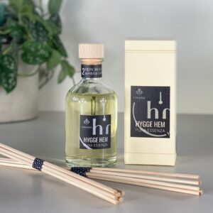 fragranza d'ambiente con diffusore a bastoncini in legno in bottiglia di vetro trasparente e tappo in legno da 100 ml al pepe rosa e ambra grigia della linea PURA ESSENZA di HYGGE HEM