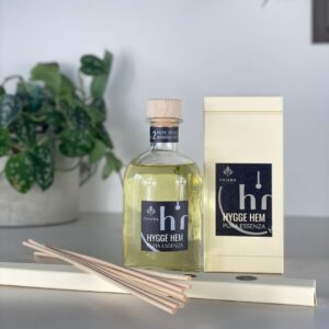 fragranza d'ambiente con diffusore a bastoncini in legno in bottiglia di vetro trasparente e tappo in legno da 250 ml al pepe rosa e ambra grigia della linea PURA ESSENZA di HYGGE HEM