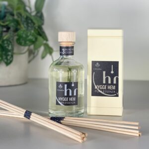 fragranza d'ambiente con diffusore a bastoncini in legno in bottiglia di vetro trasparente e tappo in legno da 100 ml al pepe rosa e cedro della linea PURA ESSENZA di HYGGE HEM