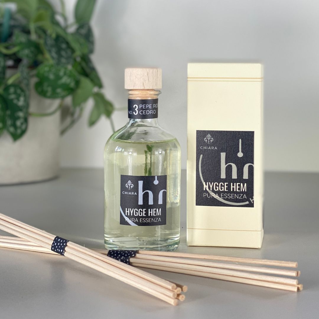 fragranza d'ambiente con diffusore a bastoncini in legno in bottiglia di vetro trasparente e tappo in legno da 100 ml al pepe rosa e cedro della linea PURA ESSENZA di HYGGE HEM