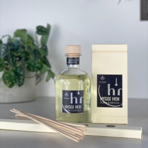 fragranza d'ambiente con diffusore a bastoncini in legno in bottiglia di vetro trasparente e tappo in legno da 250 ml al pepe rosa e cedro della linea PURA ESSENZA di HYGGE HEM