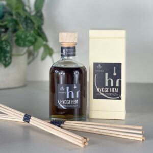 fragranza d'ambiente con diffusore a bastoncini in legno in bottiglia di vetro trasparente e tappo in legno da 100 ml al pesco e tabacco della linea PURA ESSENZA di HYGGE HEM