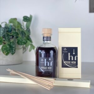 fragranza d'ambiente con diffusore a bastoncini in legno in bottiglia di vetro trasparente e tappo in legno da 250 ml al pesco e tabacco della linea PURA ESSENZA di HYGGE HEM