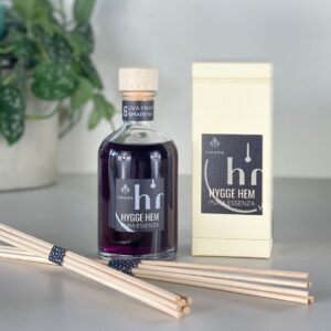 fragranza d'ambiente con diffusore a bastoncini in legno in bottiglia di vetro trasparente e tappo in legno da 100 ml all'uva fragola e amarena della linea PURA ESSENZA di HYGGE HEM