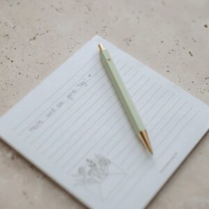 blocco note di carta bianca con penna a sfera di design minimal di colore verde matcha
