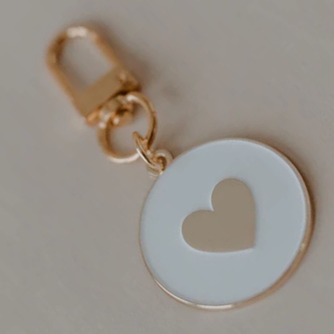 portachiavi di design con montatura color oro e medaglione smaltato bianco con inciso un cuore oro