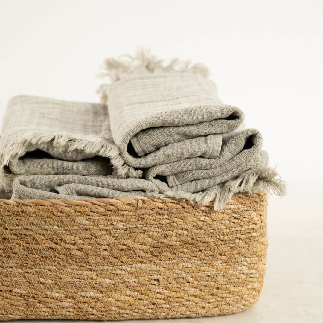 cestino in giacinto d'acqua con asciugamani in cotone testurizzato double-face color verde oliva di misura 30x50